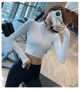 Détail du haut de yoga blanc à demi-zip avec large ceinture élastique en salle de sport
