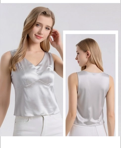 Detail showing the glossy silk satin fabric and V-neckline of the silver sleeveless top