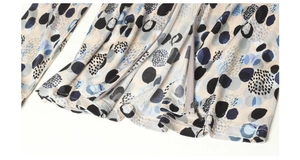 Detailed close-up of silk printed shirt showing abstract pattern and smooth metal zipper
