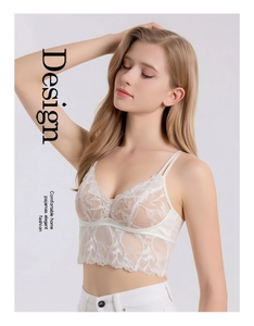 Detail view of exquisite white lace fabric with floral patterns on a silk camisole bralette