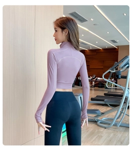 Détail d'une veste de sport lavande et d'un legging taille haute dans un gymnase
