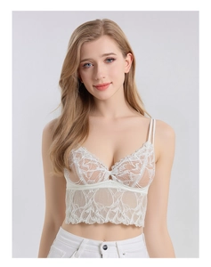 Detailed close-up of white silk lace camisole showing floral embroidery and scalloped hem