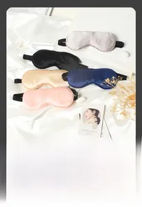 Detailed view of silk sleep masks in multiple colors on elegant white fabric background