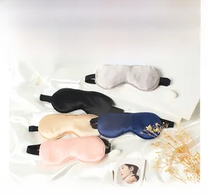 Detailed pile of silk sleep masks in grey, black, gold, blue, and pink colors
