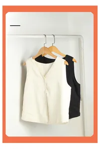 Detailed view of quilted silk jacquard vests in cream and black with button closure