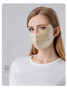 Détail macro du masque en soie champagne avec boucles d'oreilles et coupe profilée
