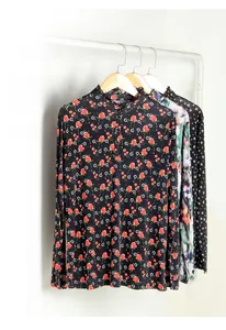 Detail of floral and polka dot silk long-sleeve tops featuring ruffled stand-up collar