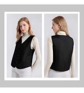 Detail view of women's black quilted silk vest with V-neck and button closure