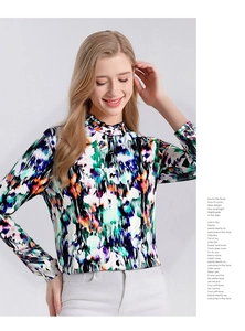 Detailed close-up of ruffle high collar and colorful abstract floral print on silk blouse