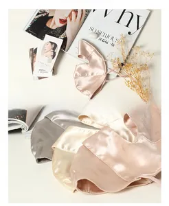 Close-up of three 100% mulberry silk face masks in nude pink, gold, and silver grey