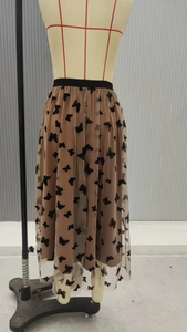 Dettaglio di gonna midi in tulle marrone a vita alta con motivi a farfalla in velluto nero
