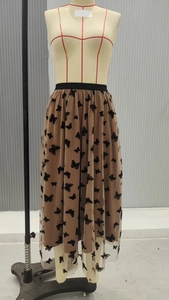 Dettaglio di gonna lunga in tulle da donna con stampa a farfalla e vita elasticizzata