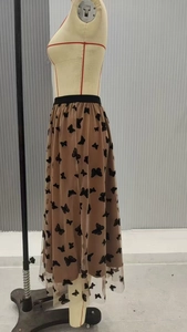 Dettaglio della gonna in tulle color caffè con motivi a farfalla ed elastico in vita