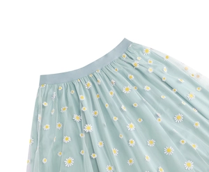 Detail of light blue mesh skirt featuring elastic waistband and white daisy floral embroidery
