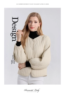 Detailed close-up of cream quilted silk jacket with metal buttons and v-neck design