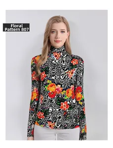 Detailed close-up of vibrant orange floral print on fine wool turtleneck top
