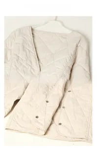 Detail der gesteppten Innenjacke mit V-Ausschnitt, Rautenmuster und Druckknöpfen