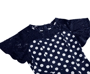 Detail of navy blue polka dot dress featuring floral lace neckline and back zipper
