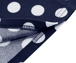 Detailed close-up of neat overlock stitching on polka dot print party dress hem
