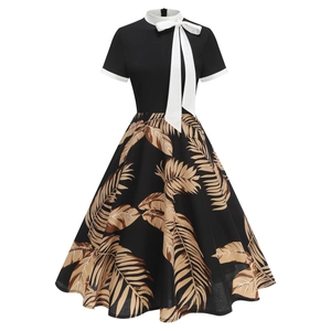 Detail of vintage A-line dress with bow collar and palm leaf print on dark fabric