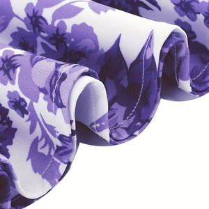 Detailed view of floral print fabric with purple blooms and fine white stitching lines