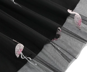 Close-up of pink flamingo embroidery and black tulle hem detail on high-waist skirt