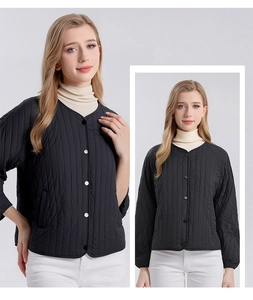Detailed view of women's black vertical quilted silk jacket with silver snap buttons