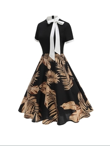 Close-up of retro floral A-line dress with white bow collar and palm leaf print
