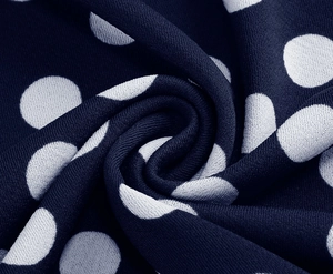 Close-up of navy blue polka dot fabric with delicate texture and soft drapery folds