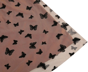 Dettaglio della gonna in tulle a vita alta con elegante ricamo di farfalle nere