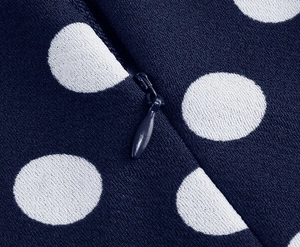 Close-up of invisible zipper and white polka dots on navy blue dress fabric