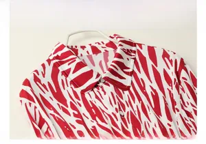 Detailed flat lay of red and white abstract printed silk shirt with refined buttons