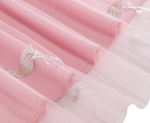 Detailed embroidery of elegant ballet dancers on delicate pink layered tulle skirt fabric