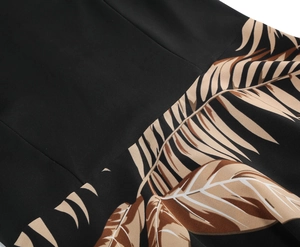 Detailed close-up of tropical palm leaf print on smooth black retro vintage dress fabric