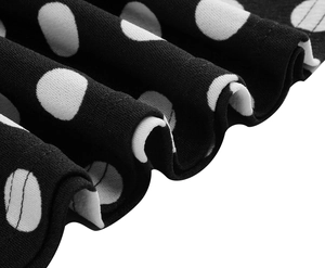 Detail of black and white polka dot fabric with elegant pleated texture on a flowing hem