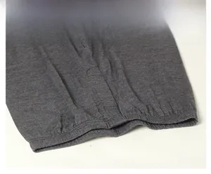 Dettaglio dei pantaloni termici grigio scuro con elastico in vita e tessuto a maglia
