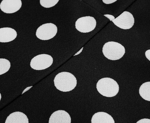 Close-up of black polka dot fabric showing detailed stitching and high-quality texture