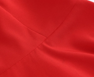 Gros plan sur le tissu satiné rouge montrant la texture croisée et les coutures nettes