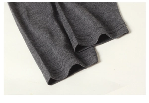 Dettaglio ravvicinato di leggings termici in lana grigio scuro con polsini elastici e cuciture