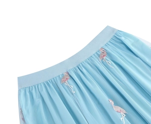 Close-up of pink flamingo embroidery on high-waist light blue mesh tulle midi skirt