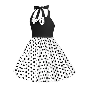 Abito vintage da bambina allacciato al collo con pois e fiocco nero su sfondo bianco
