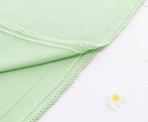 Close-up of internal overlock stitching on mint green daisy embroidered tulle skirt