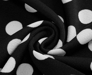 Macro view of black fabric with white polka dots showing textile texture and material layers
