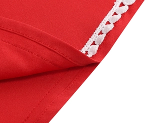 Vue macro détaillée du tissu en satin rouge avec bordure en dentelle blanche et coutures