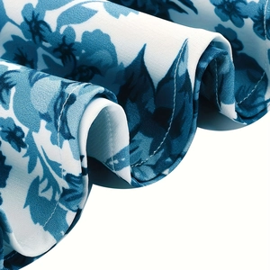 Macro shot of blue floral print fabric with neat hem stitching on the white summer dress