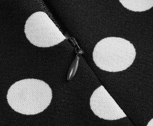 Detail view showing invisible water-drop zipper on white polka dot printed dress fabric
