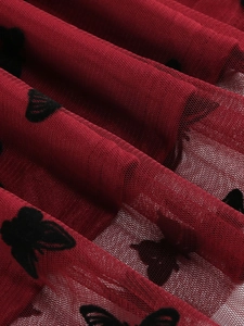 Dettaglio macro della gonna in tulle bordeaux con eleganti farfalle in velluto nero