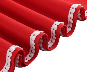 Détail d'une robe en satin rouge avec bordures en dentelle blanche et volants étagés