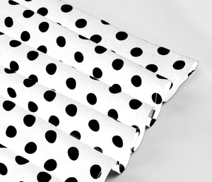 Dettaglio macro del tessuto a pois neri per abito da bambina con cuciture rifinite bene