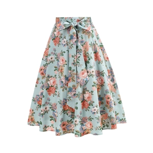 Detail of floral A-line midi skirt featuring a tie-waist bow and elegant pleated fabric